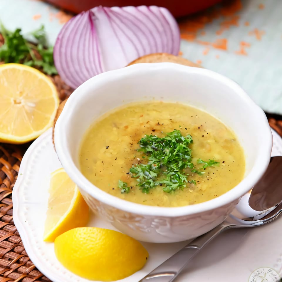 A bowl of Habibi Mediterranean Grill's lentil soup, garnished with parsley and lemon wedges.